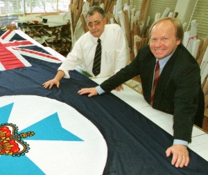 Peter Beattie MP, Premier of Queensland and Minister for Trade and our Managing Director, Darrell Lane looking over the Queensland state flag that flew upon the Sydney Harbour Bridge after our victorious “2001 State of Origin” Rugby League team won over the New South Wales team.